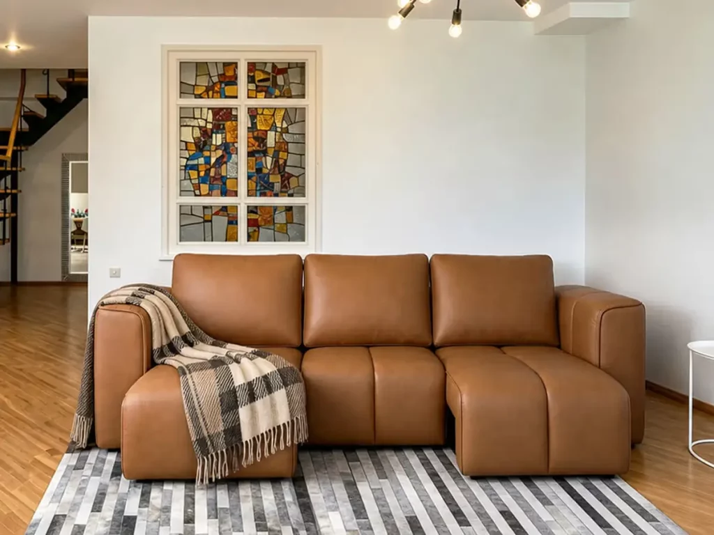 Brown leather sleeper sofa with chaise in a bright modern living room