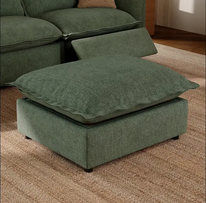Green upholstered ottoman with cushion placed in front of a modular sofa.