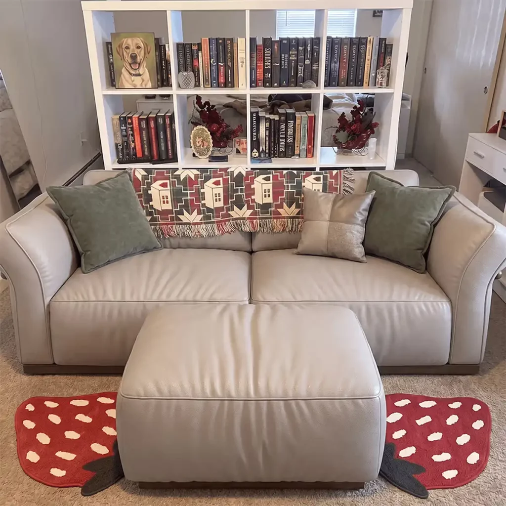 Soft beige leather sofa with relaxed seat cushions and a matching ottoman in a cozy home