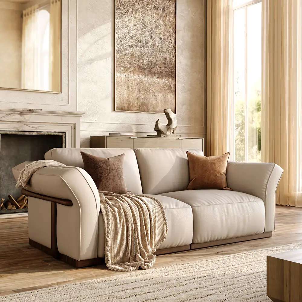 Cream leather sofa in a warm neutral living room with textured pillows, a woven throw, wood accents, and soft daylight.