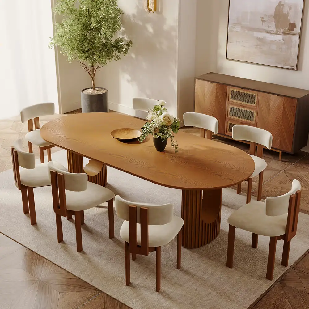 Oval wood dining table with curved upholstered chairs in a bright modern dining room.