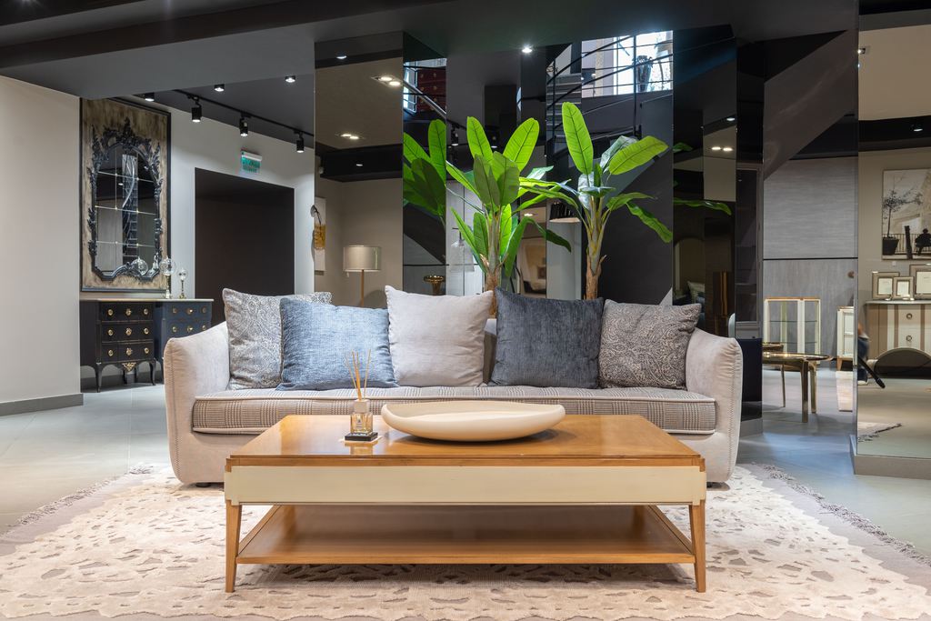 Large rectangular wood coffee table with a lower shelf in front of a light sofa in a spacious modern living room.