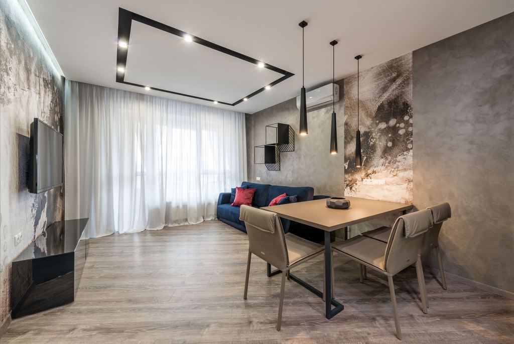 Rectangular dining table placed against a wall in a modern open-plan living and dining room.