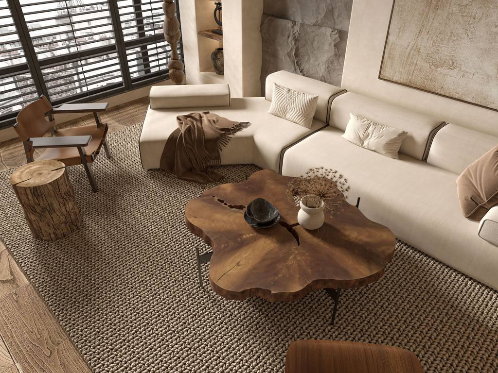 Modern Mediterranean living room with a cream sectional sofa, organic wood coffee table, woven rug, textured stone wall, and warm neutral decor.