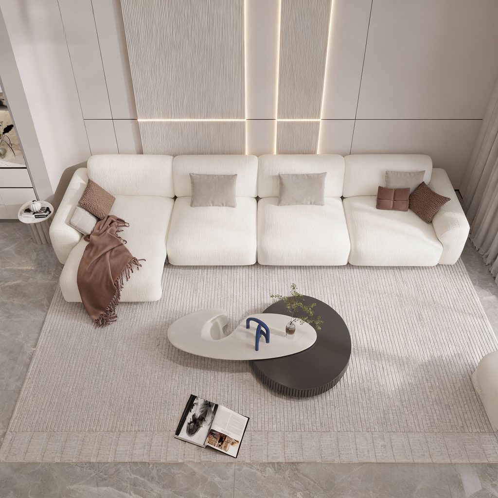 White wall-hugger sectional sofa bed with chaise in a modern neutral living room, viewed from above.
