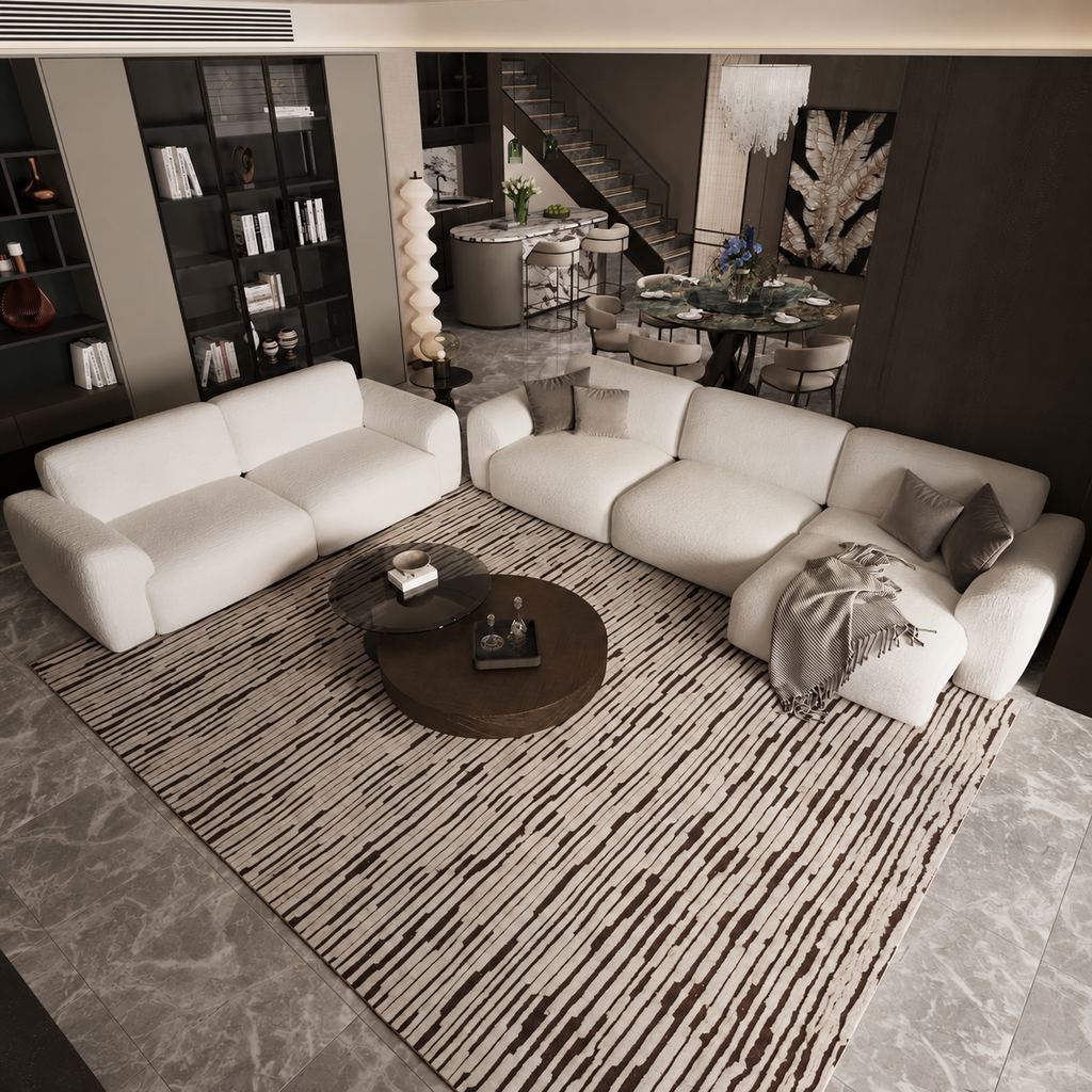 Spacious modern loft living room with white sofas, a striped area rug, round coffee tables, and an adjoining dining area and staircase.