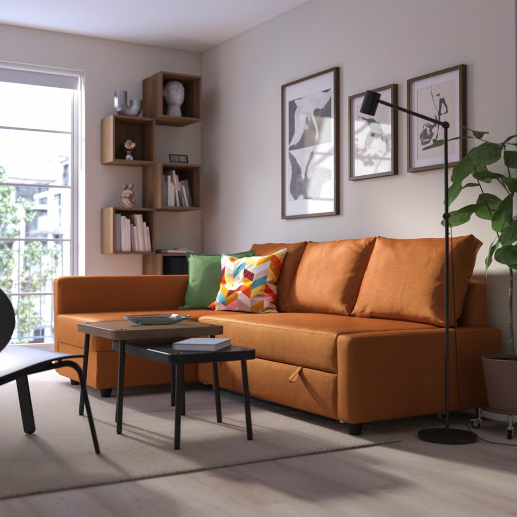 Orange three-seater sofa bed with a chaise lounge, colorful throw pillows, and built-in storage in a cozy modern living room.