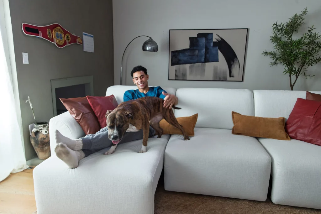 a man sitting on Aurora sofa with his dog after a long day