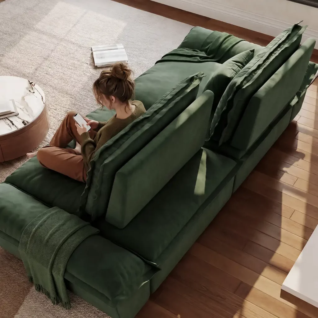 Green modular sectional sofa arranged in a spacious living room with large windows, wooden wall panels, and decorative pillows.