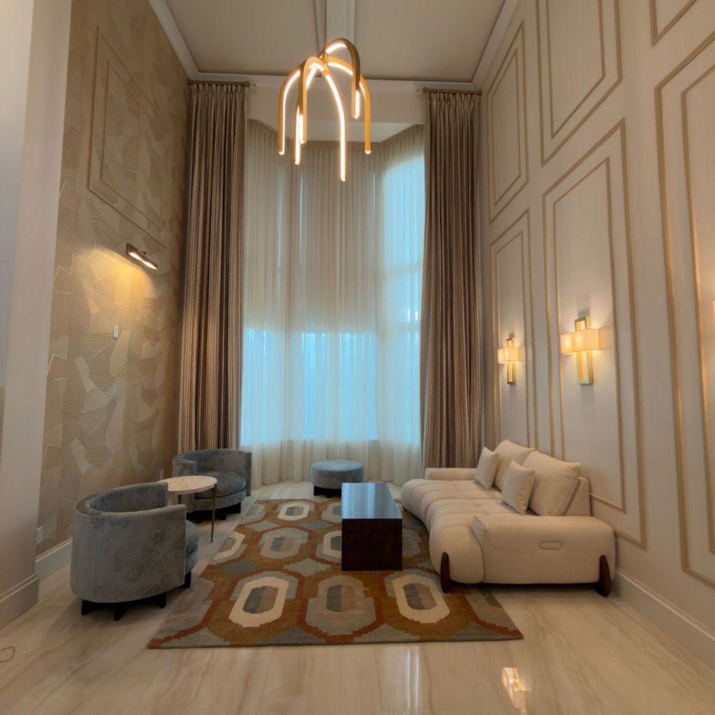 Contemporary living room with a white sofa, decorative coffee table, wall art, and warm minimalist interior design.