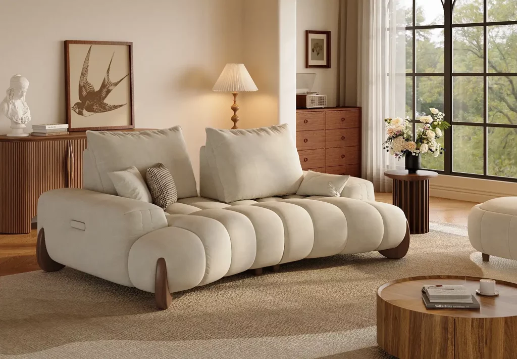 Cream-colored sofa with oversized back cushions and a deep, padded seat in a modern living room.
