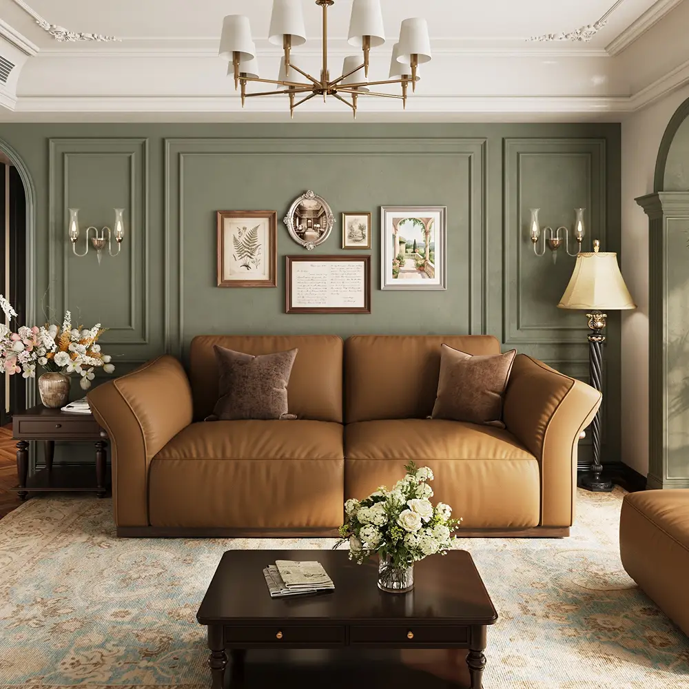 Tan leather two-seat sofa with curved arms and brown accent pillows in an elegant living room with sage green paneled walls and a wooden coffee table.