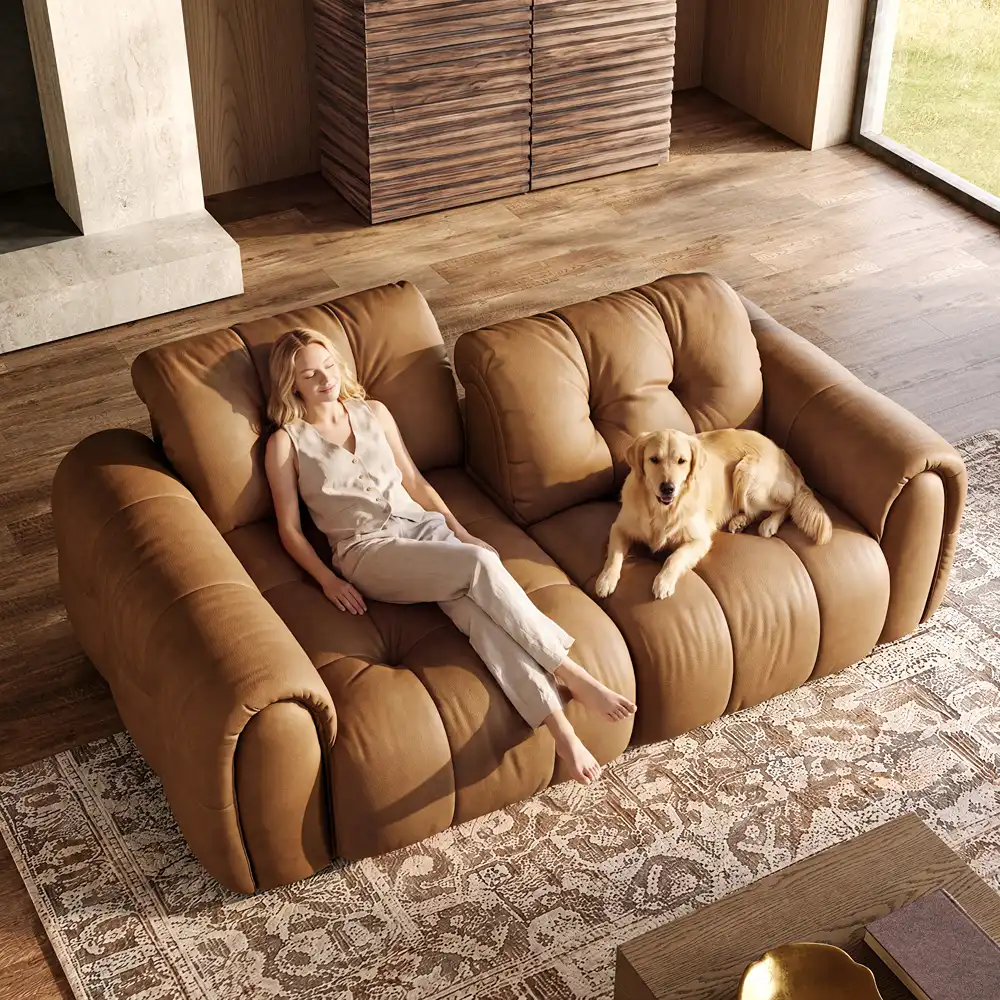 Woman stretching out on a plush, extra-deep brown leather sofa beside a golden retriever in a warm living room.