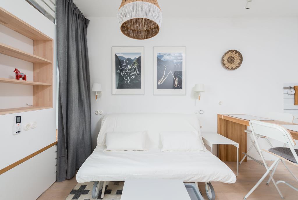 Murphy bed with a compact craft desk, folding chairs, and built-in storage in a bright multipurpose room.