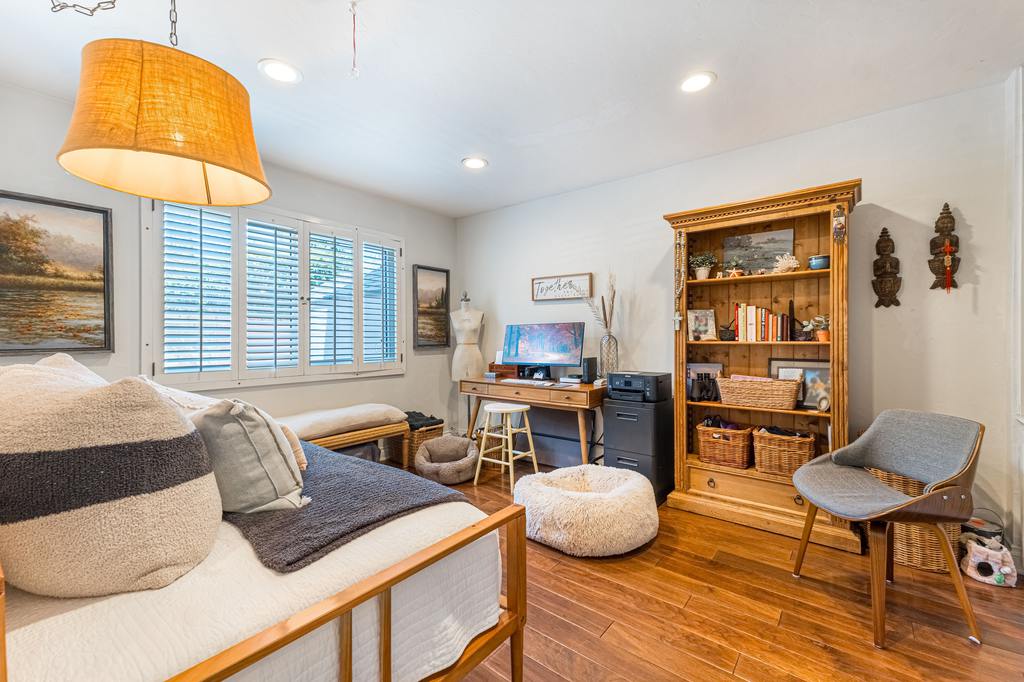 Craft room guest room combo with a bed, craft desks, storage baskets, and sewing supplies.