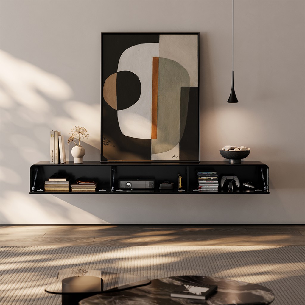 Black wall-mounted floating TV console with open storage compartments for books, electronics, and gaming accessories in a modern small den.