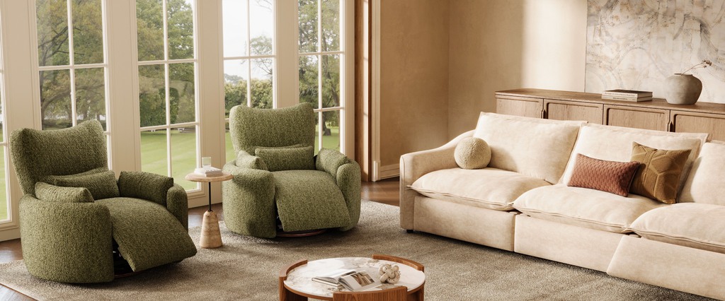 Cream sofa with an extended seat and two green reclining armchairs in a sunlit living room with large windows and a round coffee table.