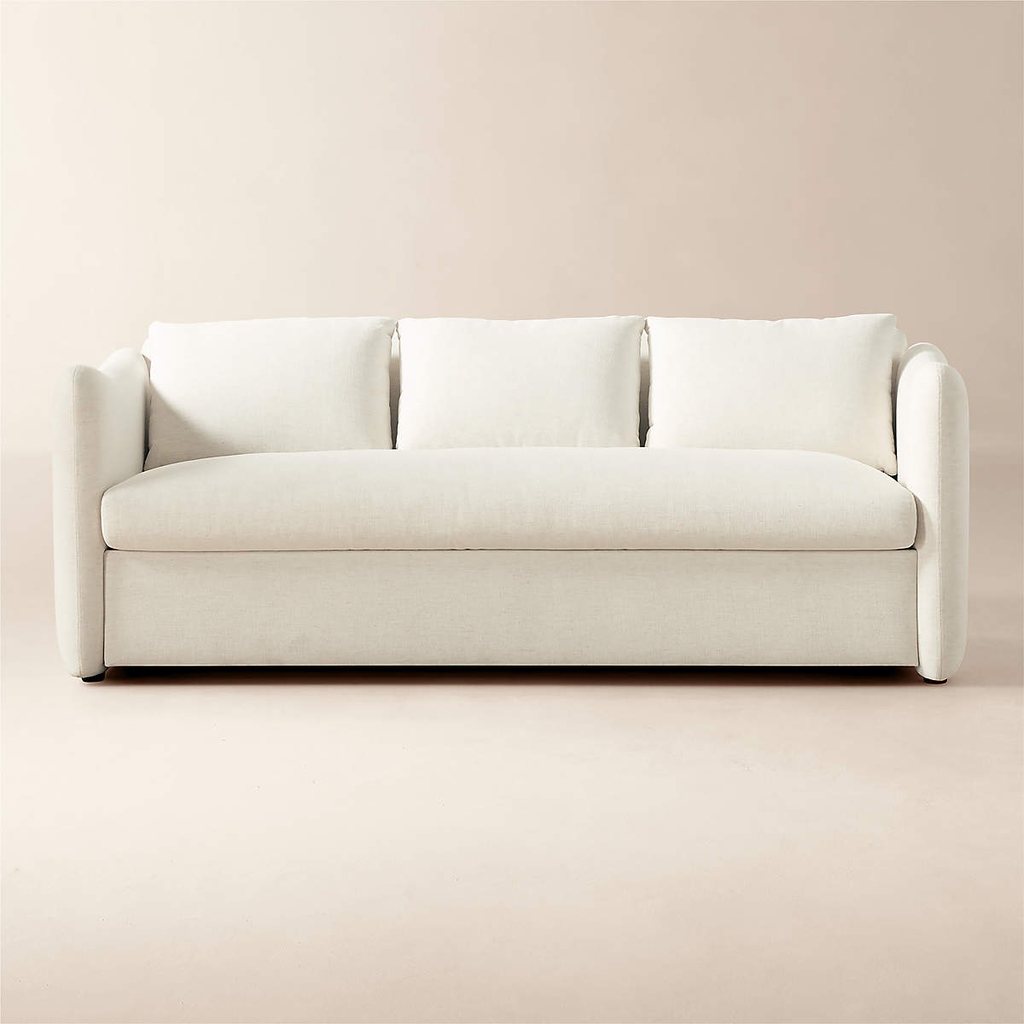 Cream-colored sleeper sofa with a deep bench seat, three plush back cushions, and rounded armrests against a neutral beige studio background.